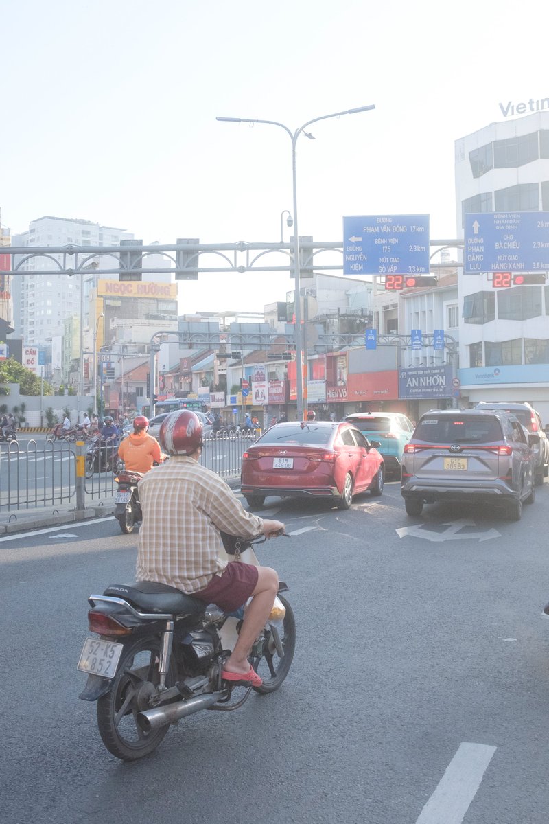 Edit city photo into rainy scene with Vietnamese bikers — example 1